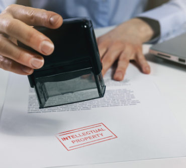 Woman putting a intellectual property stamp on document.