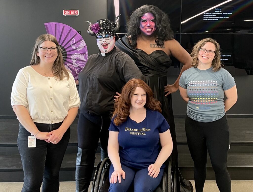 Code42 employees pose with Disabilitease performers for Pride Month celebration